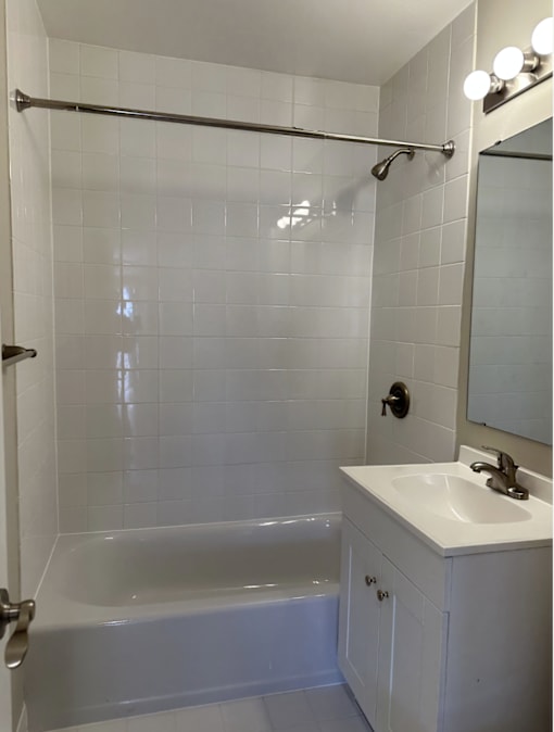A white bathroom with a white tub and sink.
