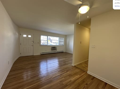 A room with wooden flooring and a window.