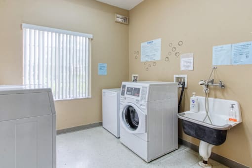 Laundry room with washers, dryers, and laundry sink