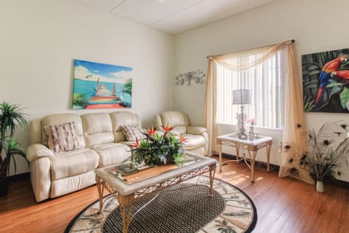 Living room with large window, hardwood-style flooring, and model furnishings