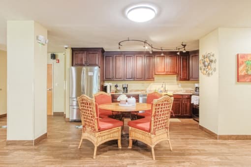 community kitchen with table, chairs, fridge, cabinetry, and track lighting