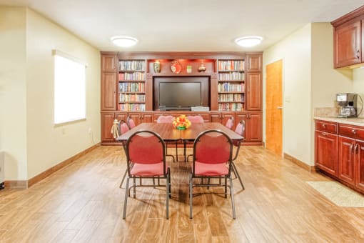 library with TV, shelves full of books, reading table, and coffee station