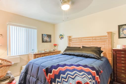 bedroom with ceiling fan, large window, and model furniture
