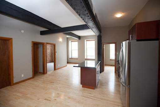 A kitchen with wooden floors and a refrigerator.