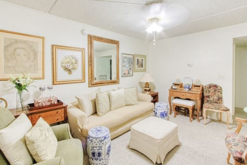 living room with ceiling fan, plush carpet and model furniture