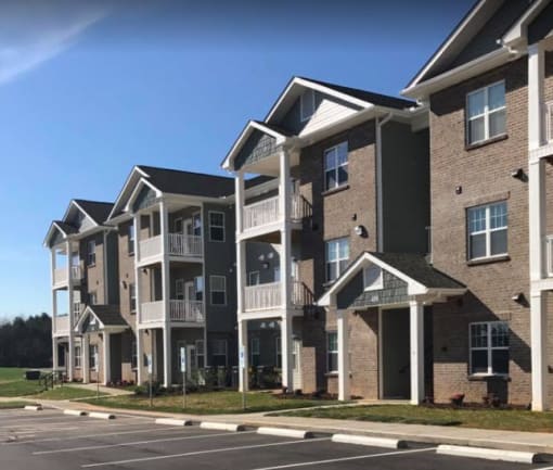 A row of modern apartment buildings with balconies and patios.