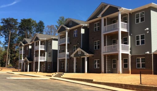 A row of new townhouses with balconies and front yards.