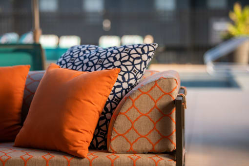 a couch with orange and blue pillows