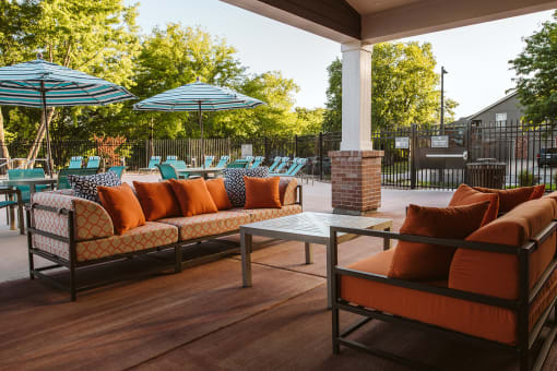 a patio with couches and umbrellas