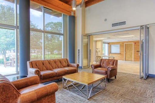 Comfortable sitting area with couches and chairs by windows in lobby