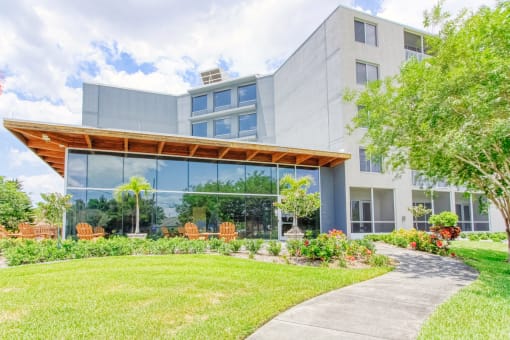 lush landscaping and outdoor seating in front of large lobby windows