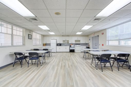 community room with kitchen and tables and chairs for residents