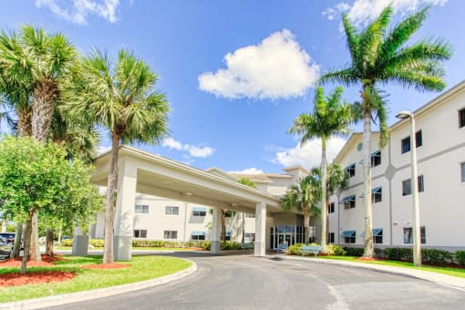 Covered drive entrance to Villa Regina and towering palm trees