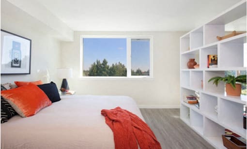 Comfortable Bedroom with White Bookcase, carpeted flooring, and large windows at Arabella Apartment Homes, Shoreline, WA, 98155