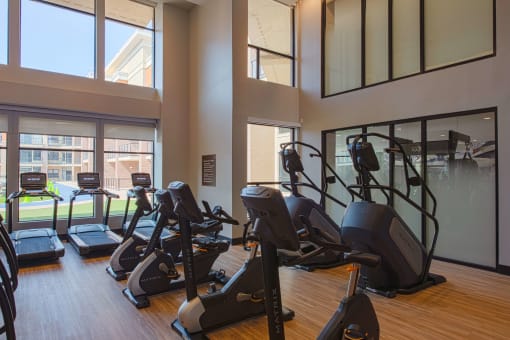 gym with rows of treadmills, ellipticals, and exercise bike at The Apex at CityPlace, Kansas