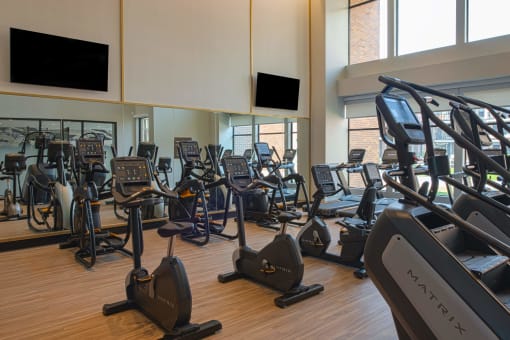 indoor gym with rows of elipticals, treadmills, and workout bicycles at The Apex at CityPlace, Kansas, 66210