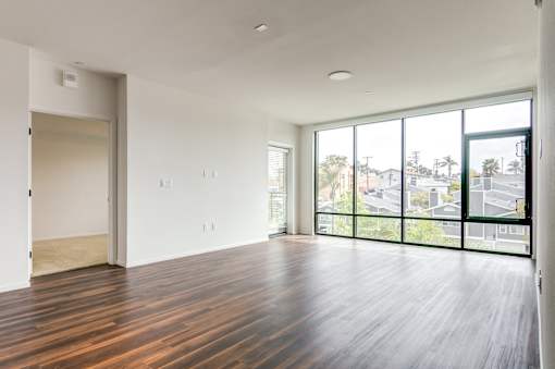 Living room with floor to ceiling windows at Vida North Park, San Diego