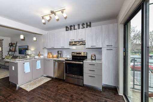 A kitchen with the word DELISH on the wall.