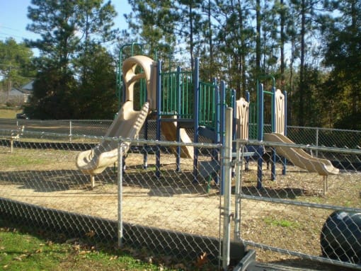 fenced play area with modern playground equipment