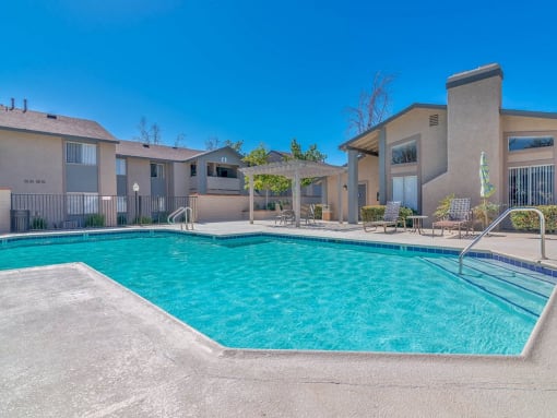 a swimming pool with apartments in the background