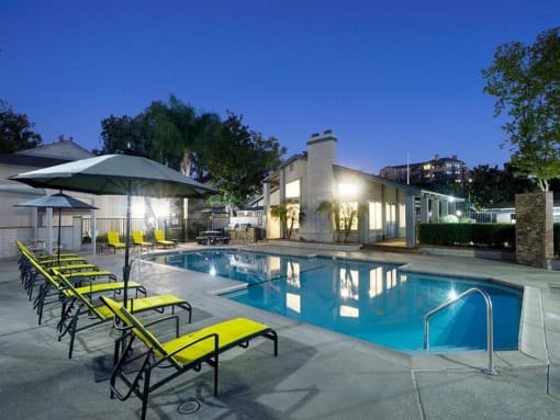 the swimming pool at night at the apartments for rent
