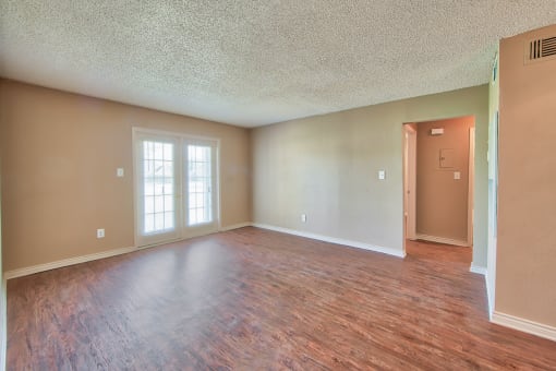 an empty living room with a hard wood floor
