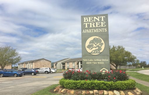 the sign for bent tree apartments in front of a parking lot