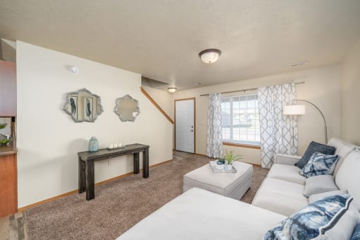 A living room with a white couch and a brown table.