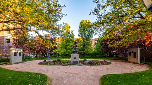 Statue in a flower area outside of First Avenue Homes