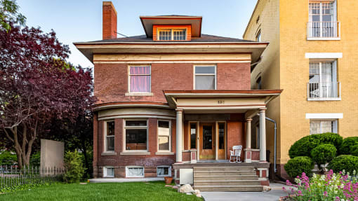 Front exterior view of red brick First Avenue Home with a view of the front yard