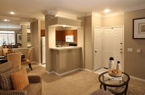 Spacious kitchen with custom home cabinets, breakfast bar, and mirror accent wall at Tuscany Park Apartments in Houston.