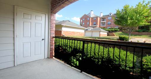 Luxury apartments with red brick exteriors, spacious balcony, and lush landscaping at TurtleCreek apartments in West Des Moines, Iowa