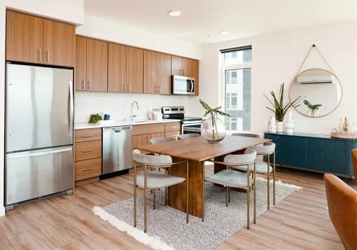 Kitchen with stainless steel refrigerator, dining table, and window