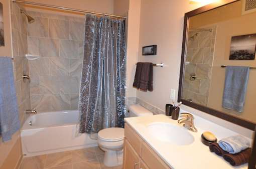 A bathroom with a white toilet, a white sink, and a shower.