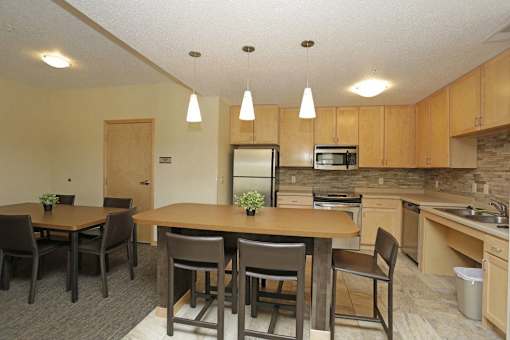 A kitchen with a dining table and chairs.