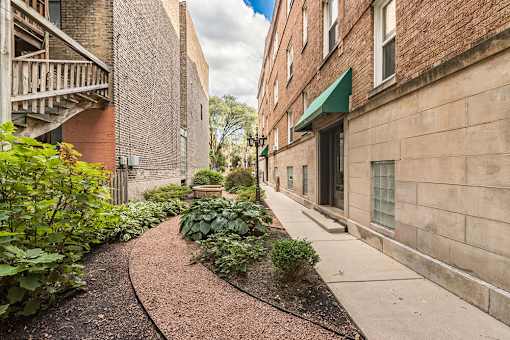 Barry Court Courtyard with a sidewalk in a garden between two brick buildings