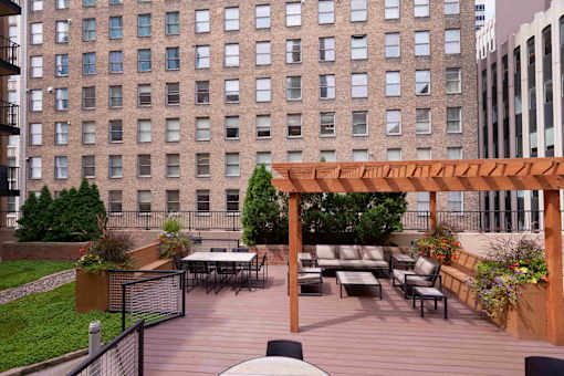 A patio with a table and chairs with a building in the background.