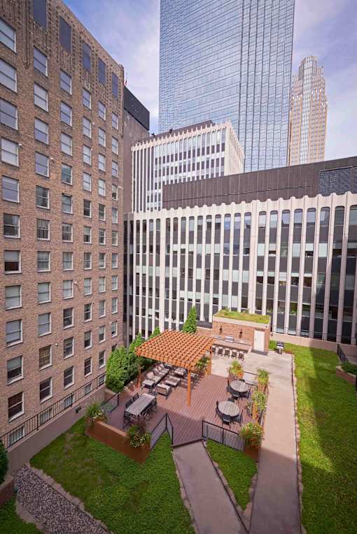 A modern building with a courtyard and a patio with a table and chairs.