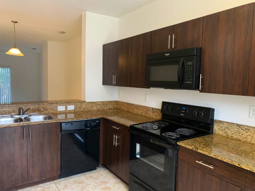 kitchen with blank appliances and dark wood cabinetry at Preserve at Boynton Beach, Boynton Beach, 33435