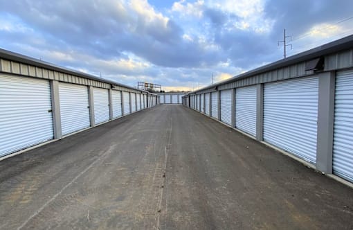 A long, empty road with a series of closed garage doors on either side.