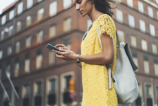 a woman in a yellow dress looking at her phone