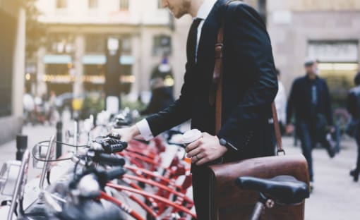 a man in a suit standing in front of a row of bikes