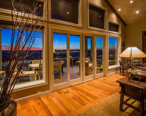 a living room with a wooden floor and large windows