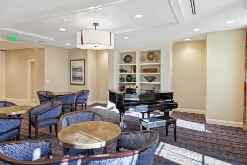 A room with a piano and chairs at White Springs Senior Living, Warrenton, VA