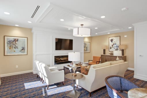 A living room with a fireplace and a painting on the wall at White Springs Senior Living, Warrenton, 20186
