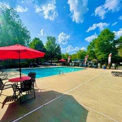 a swimming pool with tables and umbrellas at Hidden Creek, Morrow, GA