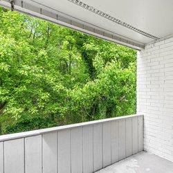 a balcony with a view of trees and a brick wall at Uphill Flats, Decatur, GA, 30032