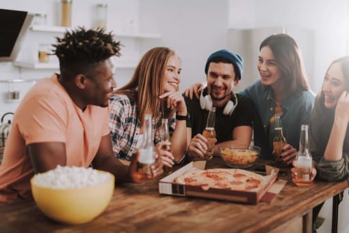 Group of young people socializing outdoors at a pet-friendly community, enjoying the friendly and welcoming atmosphere.
