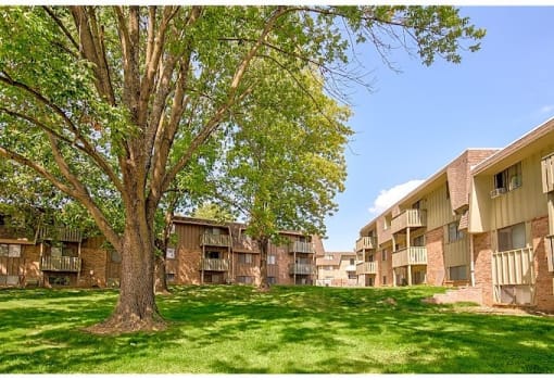 an apartment building with green grass and trees