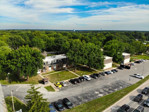 an aerial view of a parking lot with cars and buildings
